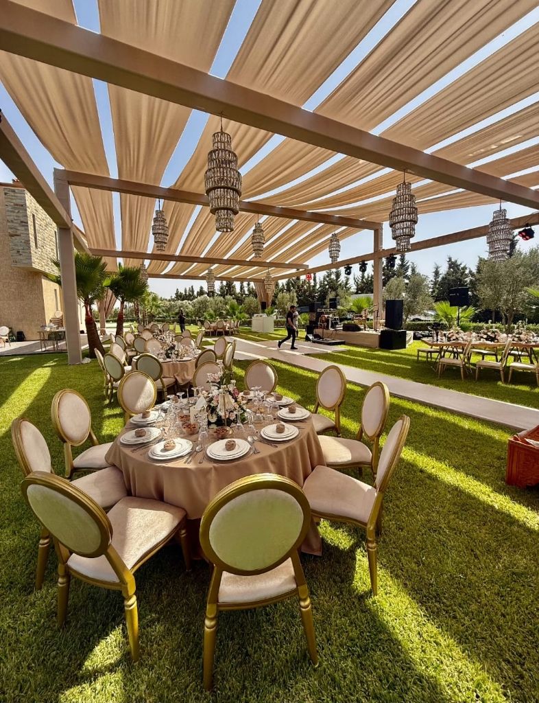 Réception en plein air sous pergola, tables élégamment dressées